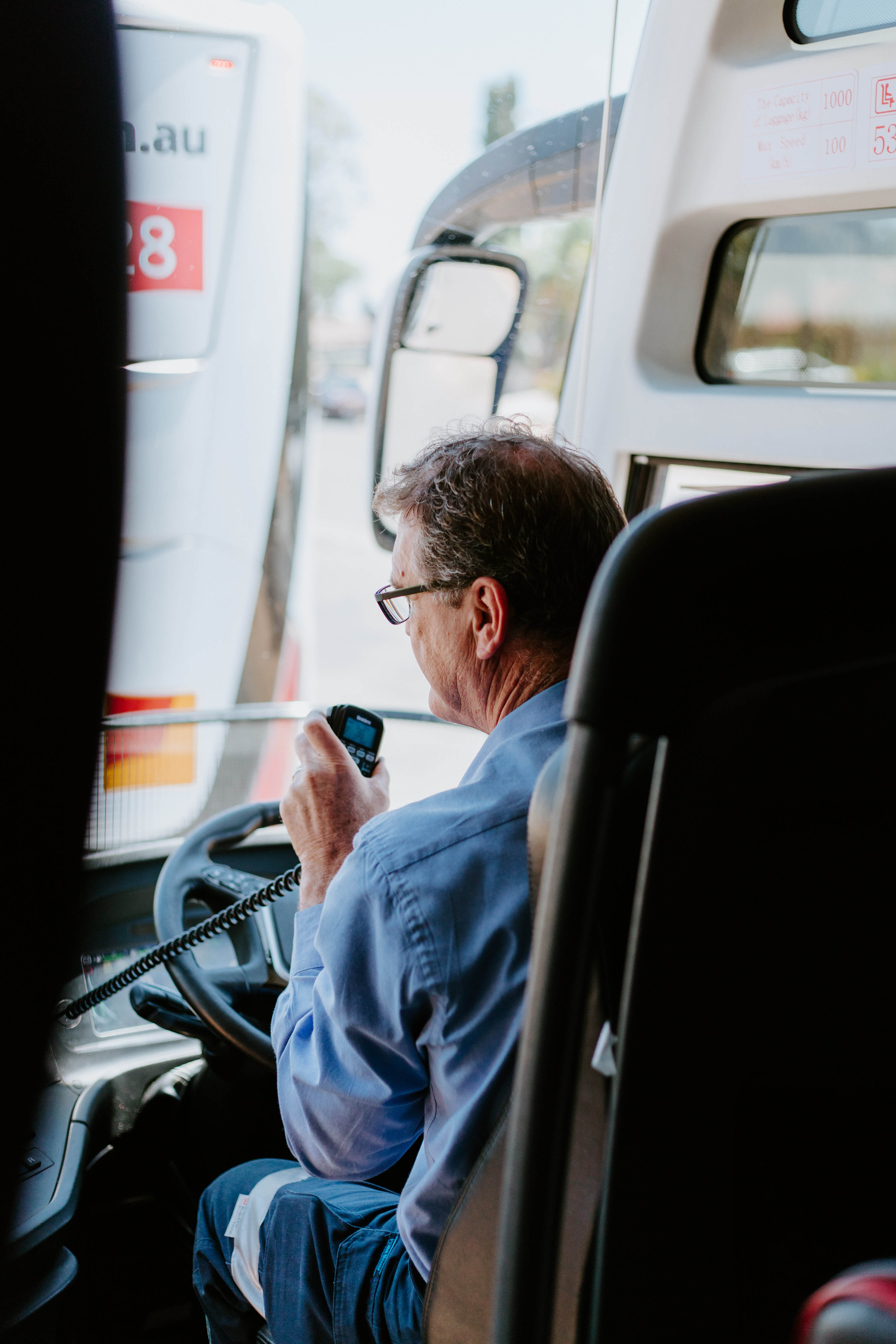 A bus driver talks into his radio mic while parked.